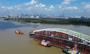 西贡河步行桥钢拱主跨段完成水路拖航，定于10月21日合龙 · 报道配图