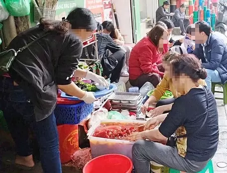 越南讀者反映街頭攤販戴手套收錢後繼續抓取食物 · 報道配圖