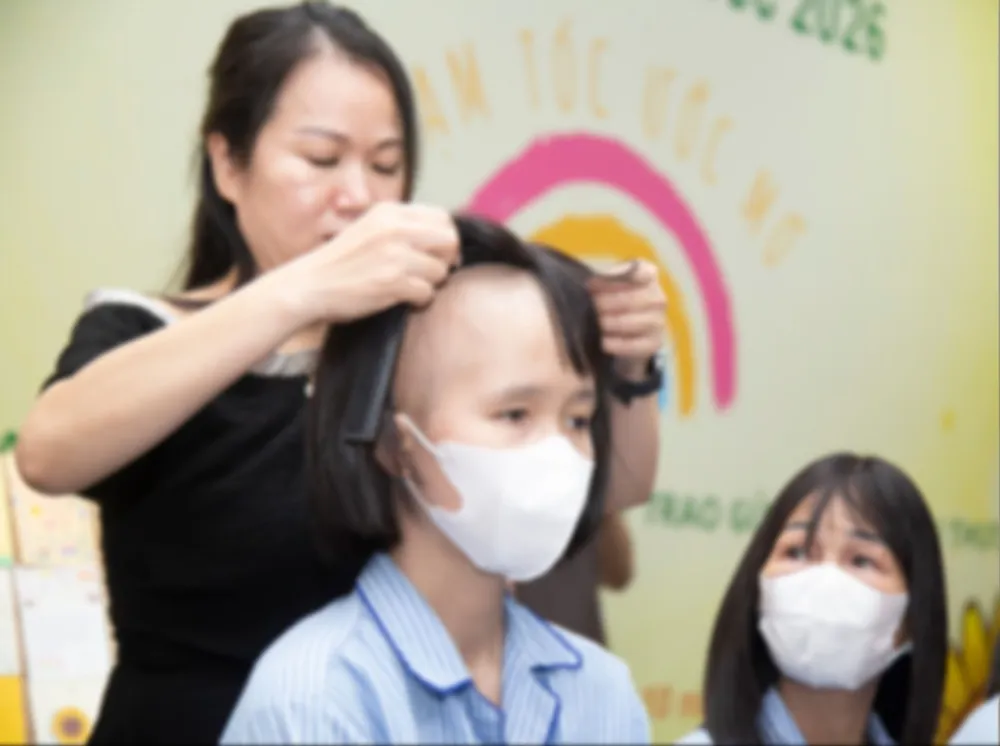一名癌症患者高兴地领取了“梦想发站”项目赠送的假发。